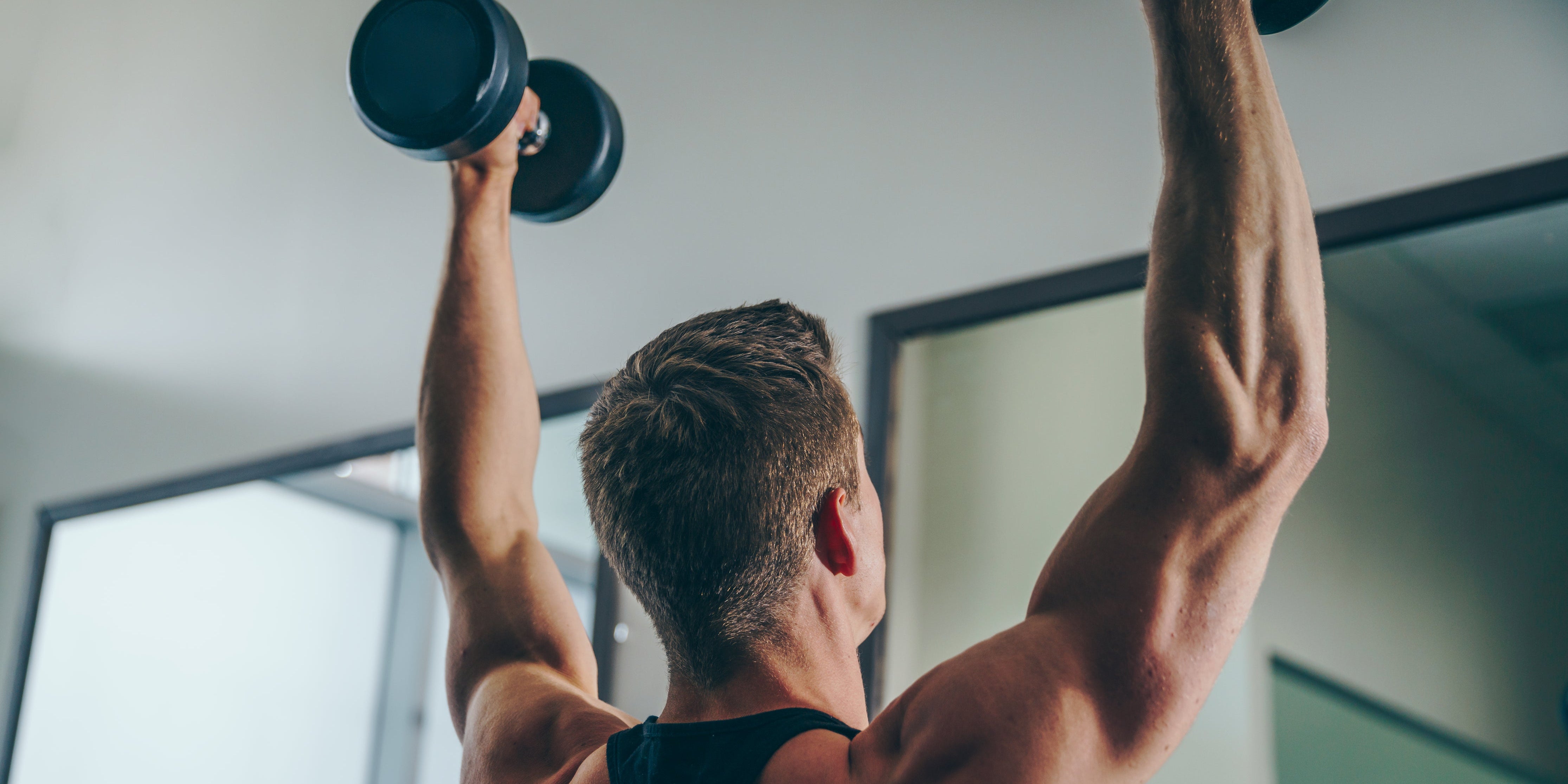Man lifting weights to help address age-related muscle loss.